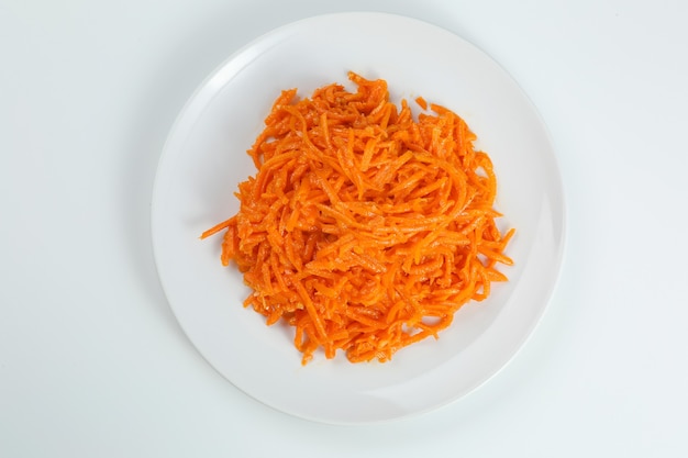 Korean carrots salad closeup in white plate isolated on white background. traditional Korean salad with carrot