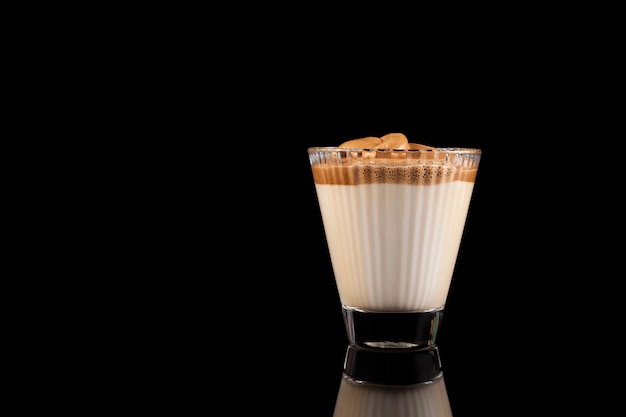 Korean drink Dalgona coffee in a beautiful glass. Cold milk with foam of instant coffee.