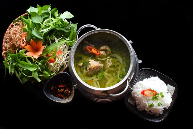 Korean hot pot with chicken meat and noodles on black background