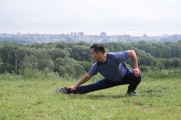 Korean man stretches against the background of the city