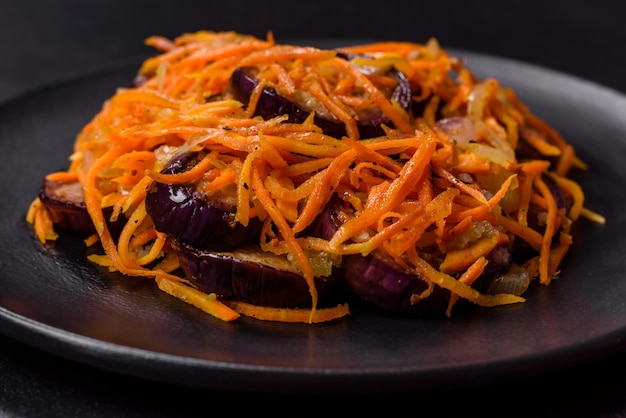 Korean salad with eggplant carrots garlic spices and herbs on a dark concrete background