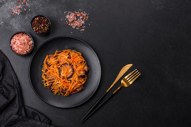 Korean salad with eggplant carrots garlic spices and herbs on a dark concrete background