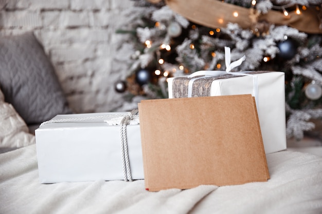 Kraft envelope is lying on the bed against the the Christmas tree