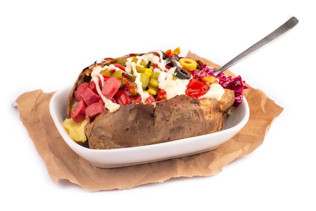 Kumpir, Turkish baked potato with cheese, corn, sausage, ketchup, mayonnaise and olives. This kumpir is traditional turkish food isolated on white background