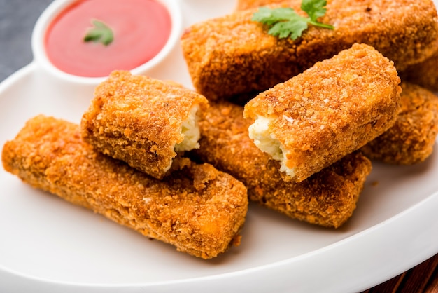 Kurkuri paneer fingers or pakora, pakoda snacks also known as Crispy Cottage Cheese Bars, served with tomato ketchup as a starter. selective focus