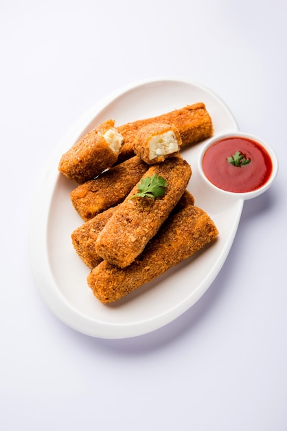 Kurkuri paneer fingers or pakora, pakoda snacks also known as Crispy Cottage Cheese Bars, served with tomato ketchup as a starter. selective focus