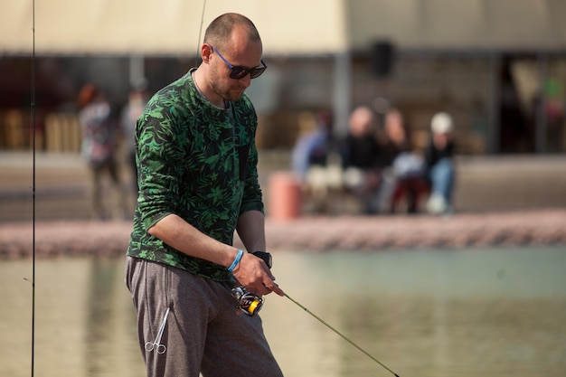 Kyiv, Ukraine April 16, 2018. Caucasian fisherman catches fish with a spinning rod on the lake.