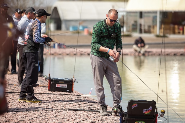 Kyiv, Ukraine April 16, 2018. Caucasian fisherman catches fish with a spinning rod on the lake.