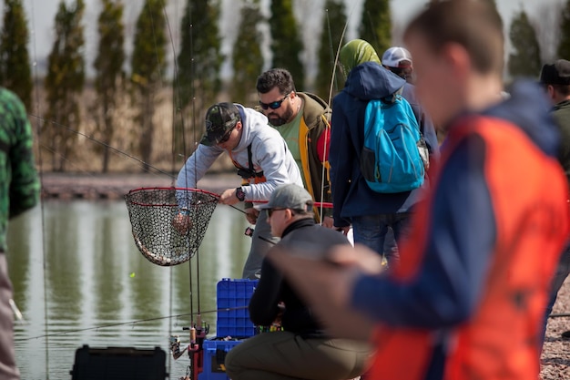 Kyiv, Ukraine April 16, 2018. A fisherman cuts off a fishing line for a fish in a landing net.