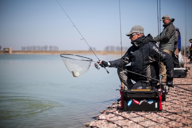 Kyiv, Ukraine April 16, 2018. A fisherman with a spinning rod, holds a fish in a landing net.