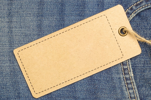 Label price tag mockup on blue jeans from recycled paper.