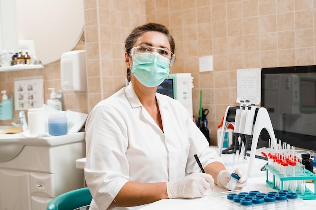 Laboratory assistant holds test tubes for gynecological and cytological analysis Woman scientist working in medical lab