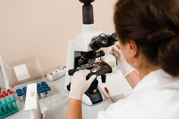 Laboratory assistant looks into microscope and makes blood test in the laboratory Medical equipment for hematological and biochemical blood tests in a medical clinic