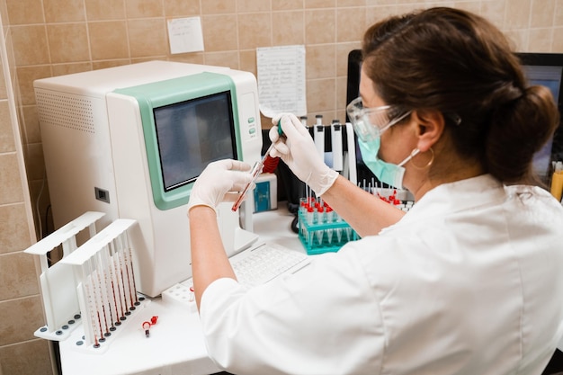 Laboratory assistant works on blood analyzer and makes hematological analysis in the laboratory Medical equipment in the lab Biochemical and hematological analysis of blood