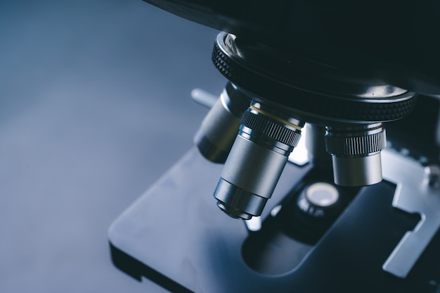 Laboratory equipment optical microscope, closeup of scientific microscope with metal lens, data analysis in the laboratory