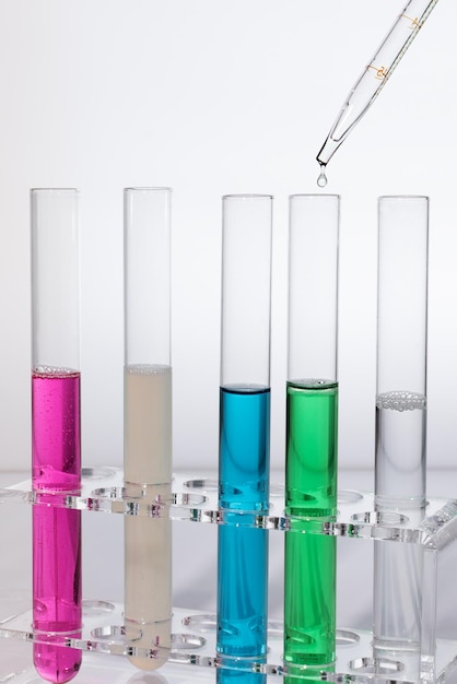 Laboratory test tubes with colorful reagents and pipette with drop Medical research concept