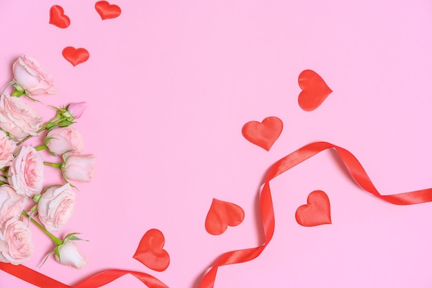 Lace ribbon and hearts and pink rose flowers on a pink background Happy