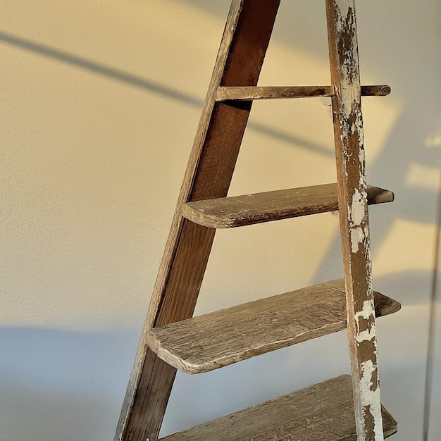 a ladder is made of wood and has a shadow on the wall