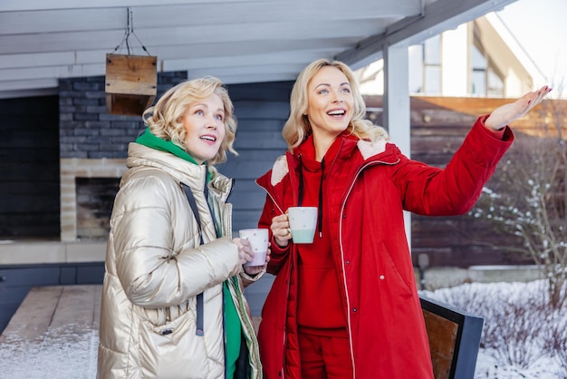 Ladies with mugs of coffee standing outdoors