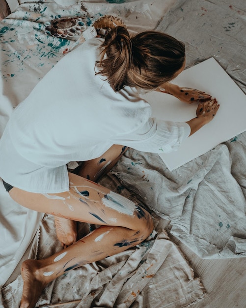 Lady draw a watercolor heart on white canvas