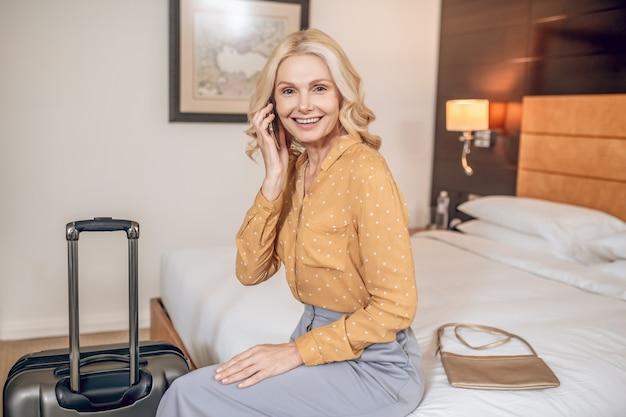 Lady. Elegant blonde woman in grey pants in a hotel room