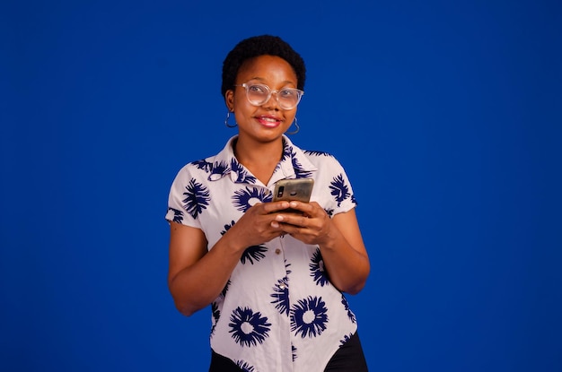 Lady isolated over blue background using her phone