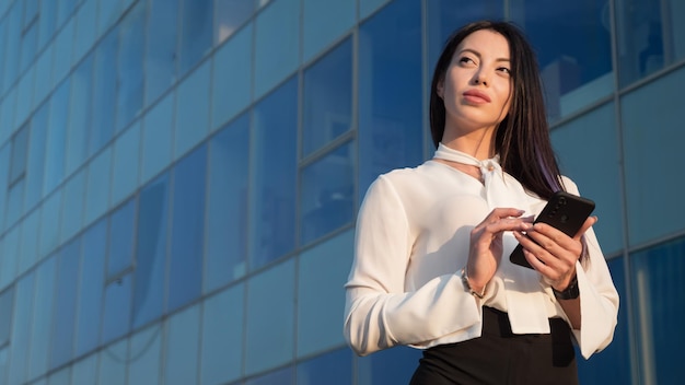 Lady manager stands against business center facade and chats