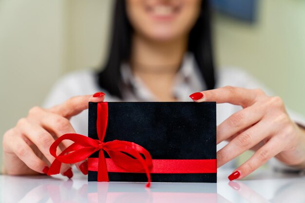 Lady presenting gift card for business Voucher holding in female hands