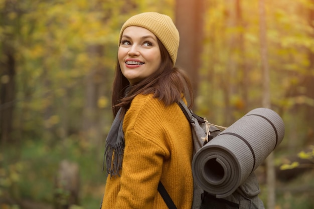 Lady walks through autumn forest searching for mushrooms