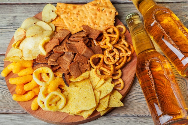 Lager beer and snacks on wooden table. 