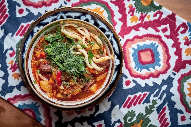 Laghman soup with meat, vegetables and pulled noodles served in plate.