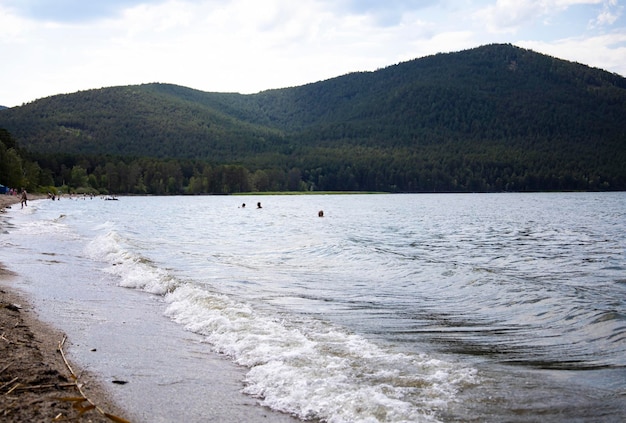 Lake and in the background is a mountain. Beach for relaxation in a mountainous area.