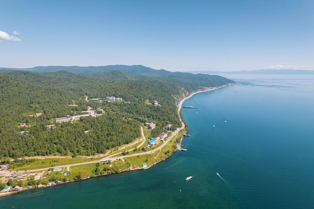 Lake Baikal is a marvelous blue jewel framed by scenic mountains and forests. Epic cinematic aerial view Lake Baikal. Aerial view of blue lake and green forests.