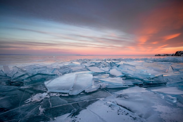 Lake Baikal at sunset, everything is covered with ice and snow, thick clear blue ice. Lake Baikal in the rays of the setting sun. Amazing place, UNESCO world heritage