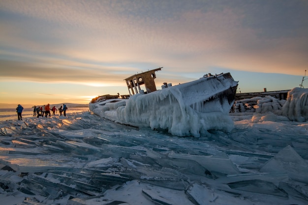 Lake Baikal at sunset, everything is covered with ice and snow, thick clear blue ice. Lake Baikal in the rays of the setting sun. Amazing place, UNESCO world heritage