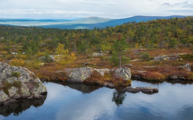 Lake beyond Arctic Circle on top of a hill in autumn