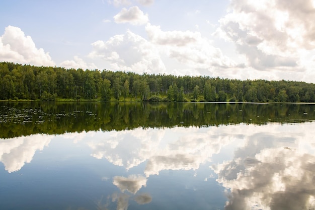 Lake in the forest Reflection of clouds in the water surface