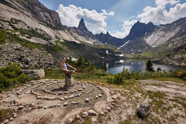 Lake of mountain spirits, woman sitting on stone