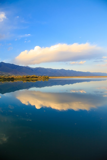 Lake in the mountains Beautiful nature reflection of clouds and mountains in blue water Kyrgyzstan Lake IssykKul