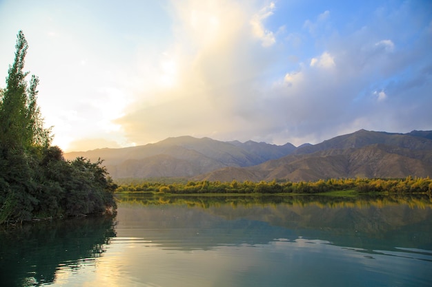 Lake in the mountains Quiet bay in the greenery at sunset Place for rest Kyrgyzstan Lake IssykKul