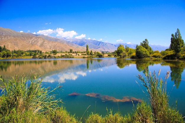 Lake in the mountains Quiet bay in the greenery at sunset Place for rest Kyrgyzstan