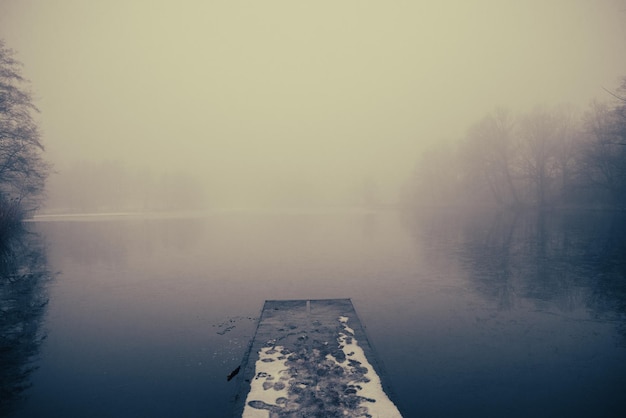 Lake pier winter and heavy fog