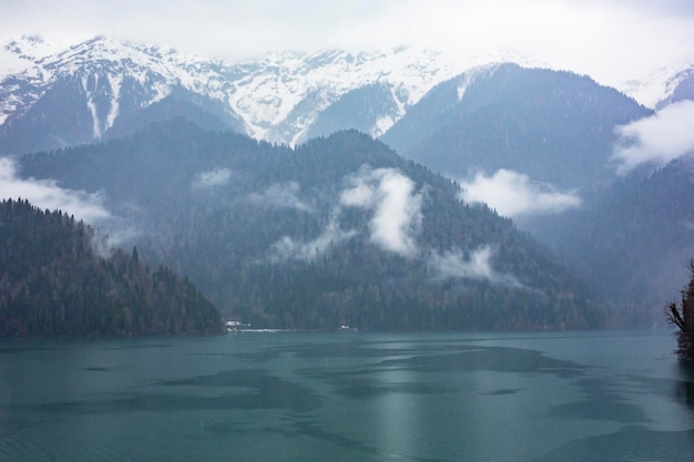 Lake ritsa in winter in abkhazia in a haze of fog at dawn