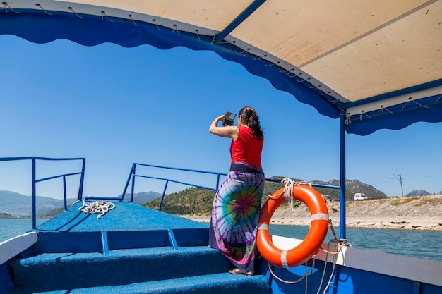 Lake Skadar Montenegro August 02 2017 A woman photographs Lake Skadar from the side of a pleasure boat