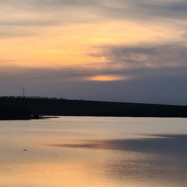 A lake with a sky that has a few clouds