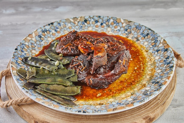 Lamb confit with snow peas in sauce on plate