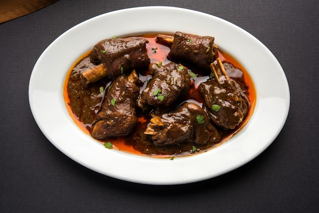 Lamb OR mutton shank, also known as gosht paya OR khoor curry served with indian Wheat Roti, selective focus