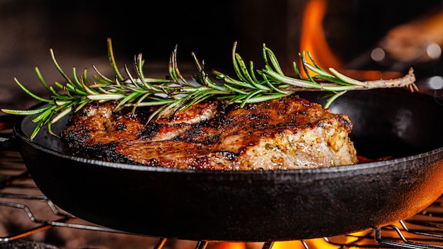 Lamb steak is fried on a fire in a cast iron pan