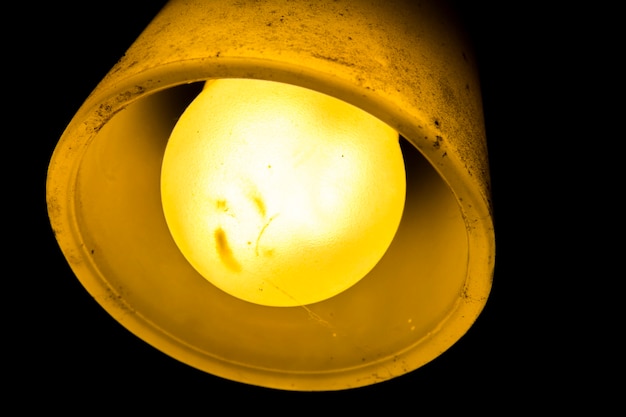 Photo lamp with old bright yellow light bulb dirty cap