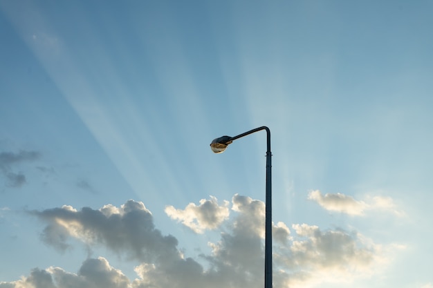 Lamppost in evening sky with the rays of the setting sun.